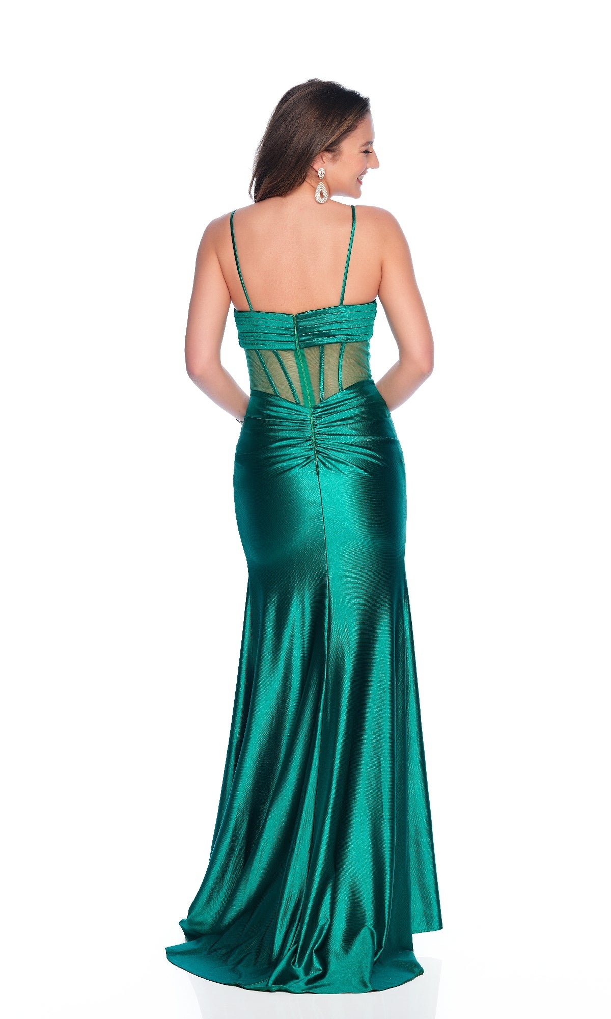 A woman stands facing away, showcasing the elegant back of the Sheer-Bodice Green Prom Dress: Dave & Johnny 12257, featuring a shiny fitted design with thin straps, sheer corset bodice, and mesh panel details.
